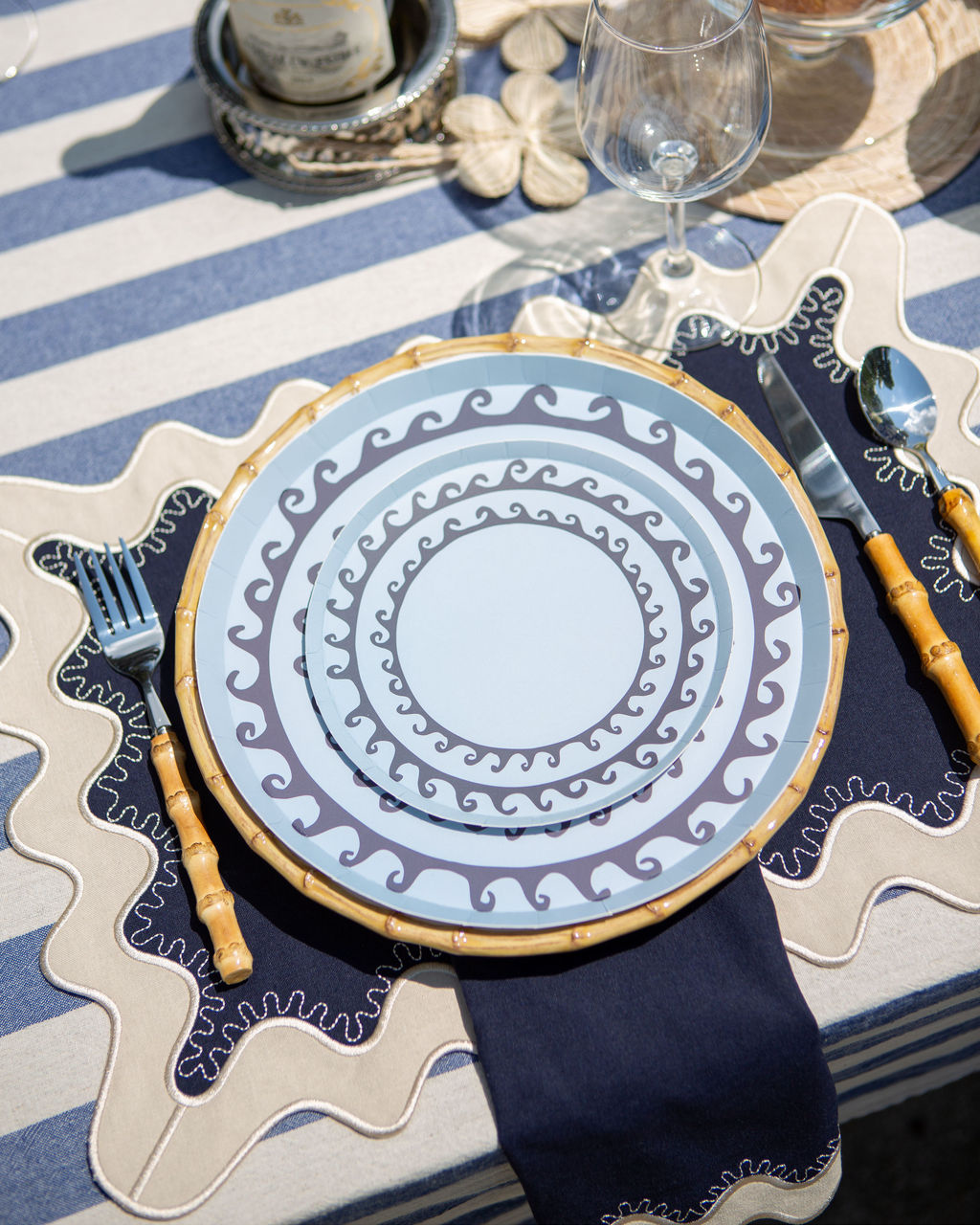 A blue themed table setting with blue paper plates featuring a wavy design