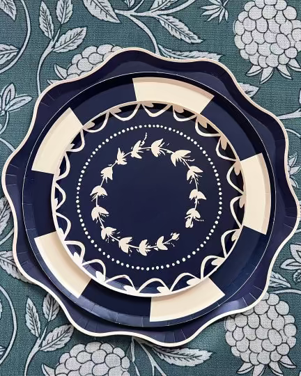 Decorative navy blue plate with white floral patterns on a floral patterned background