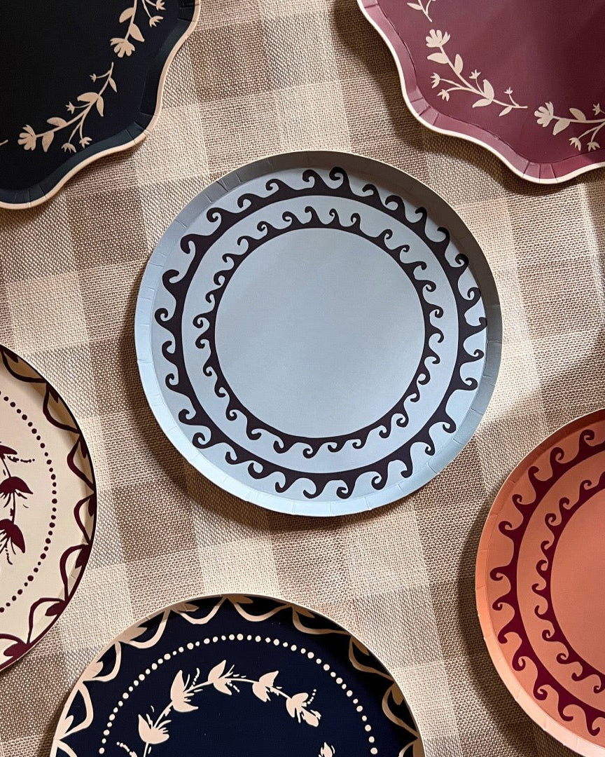 Collection of decorative plates with various patterns on a checkered tablecloth.