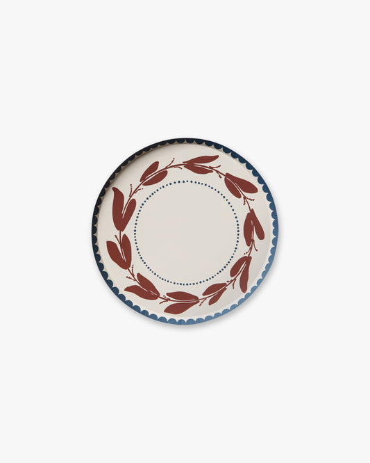 Decorative plate with a red leaf pattern on a white background