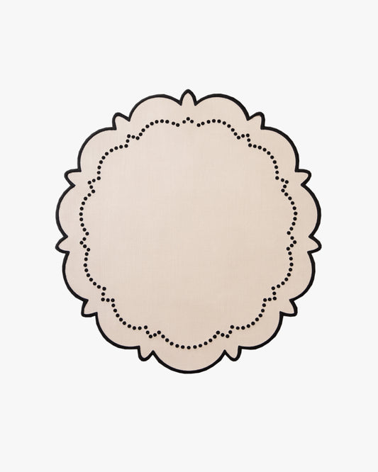 Round beige doily with a dotted border on a beige background