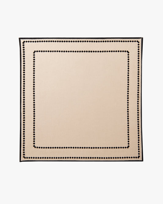 Beige placemat with black border on a white background