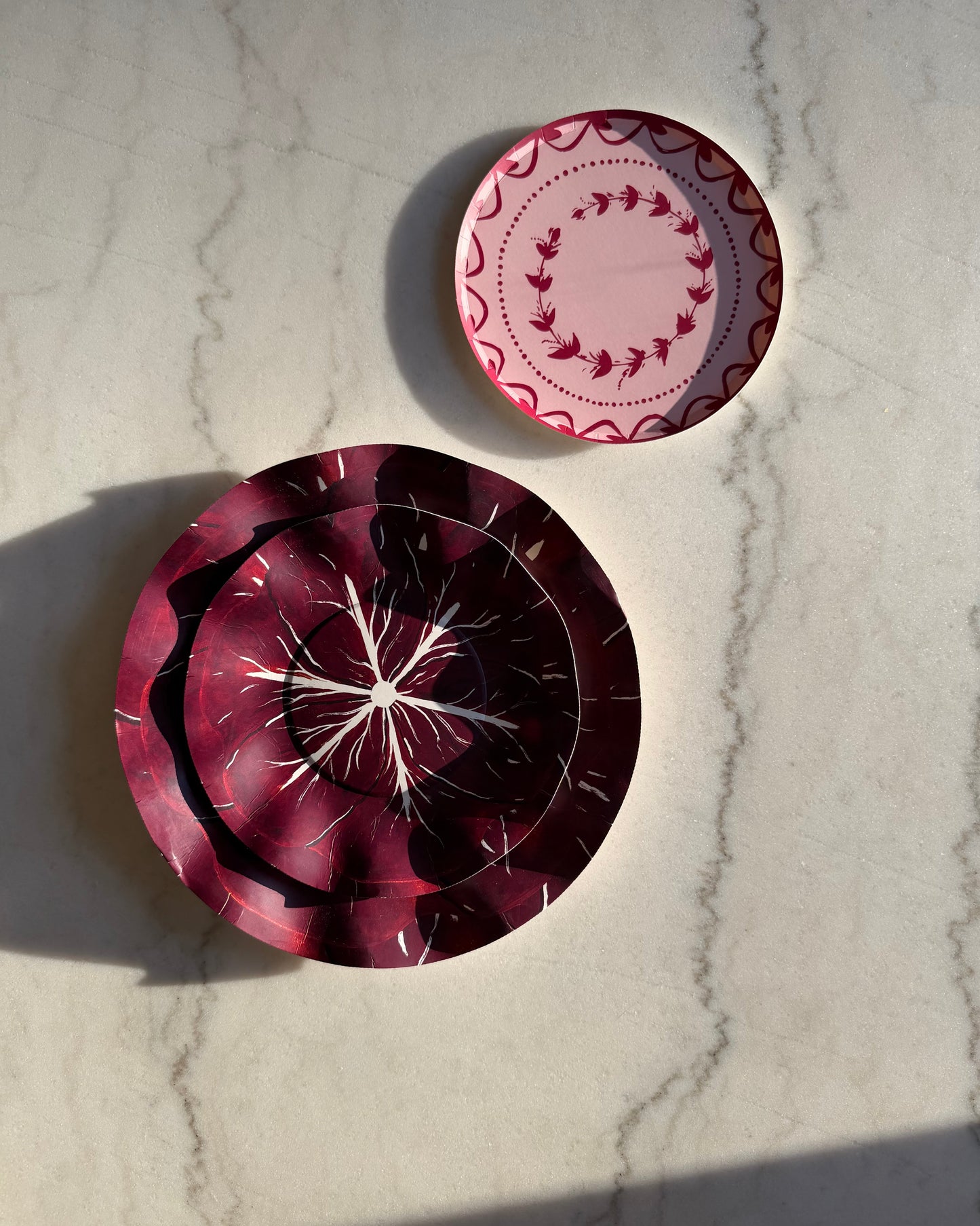 Two decorative plates on a marble counter