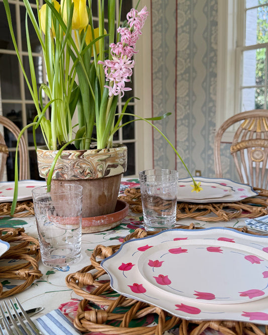 Dining table setting with floral centerpiece and decorative plates.