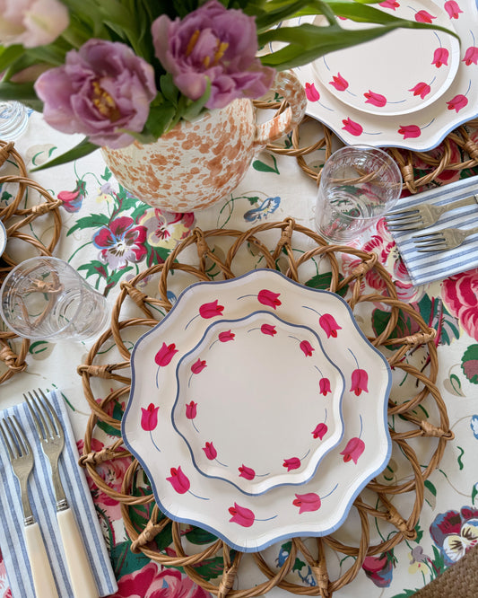 A spring table setting with two stacked paper plates with tulips on them
