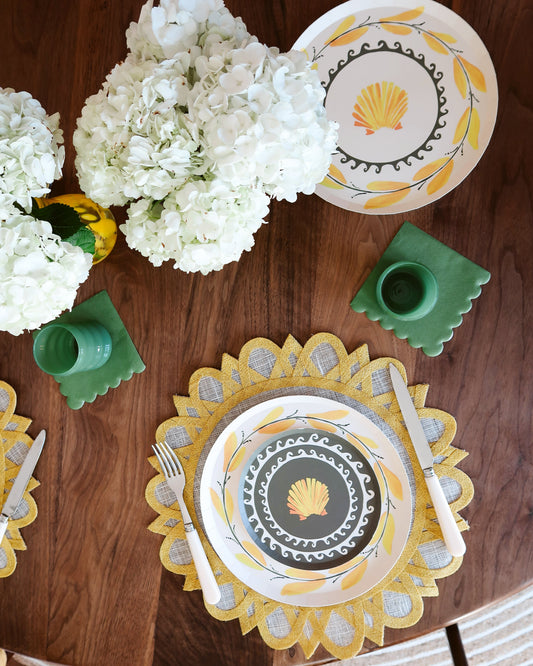 Decorative table setting with plates, cutlery, and flowers on a wooden table.