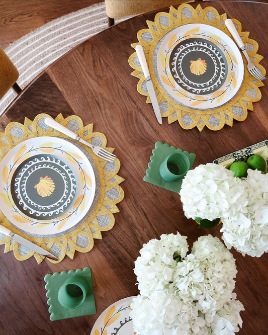 Decorative table setting with floral arrangements and patterned plates on a wooden table.