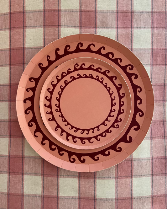 Decorative paper plate with wavy line pattern on a plaid fabric background
