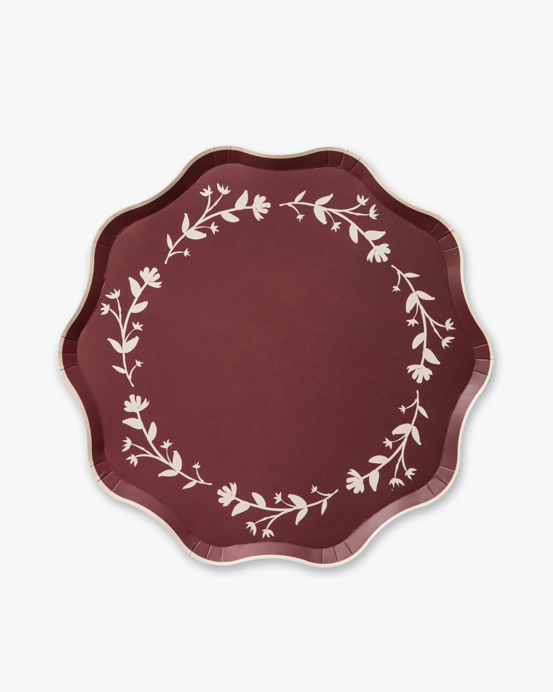 Maroon paper plate with white floral pattern on a white background