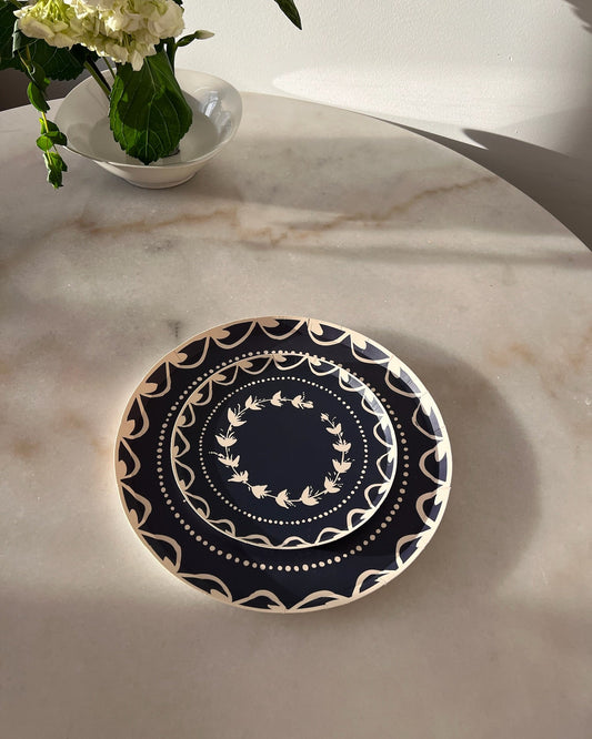 Navy blue plate with white floral pattern on a marble table.