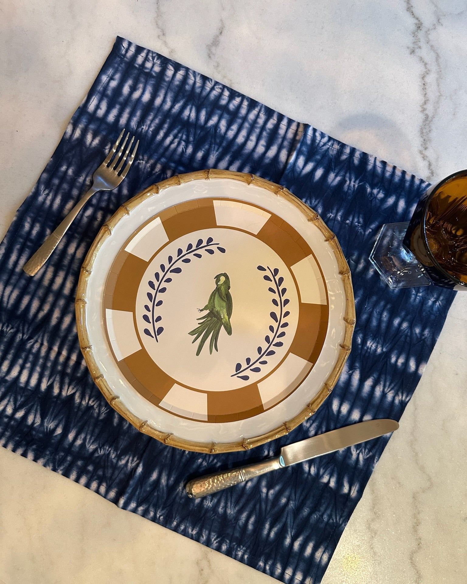 Decorative plate with a design on a blue and white patterned placemat.