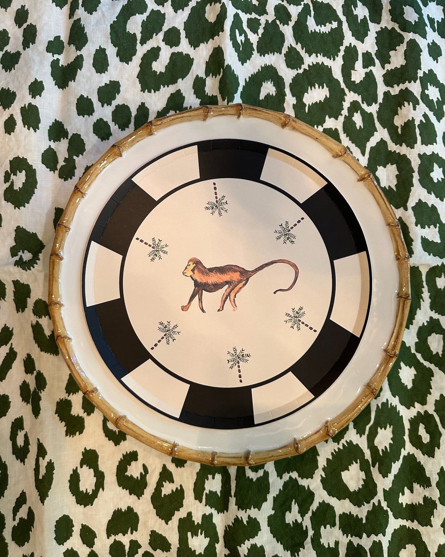 Decorative plate with a monkey design on a green and white patterned background