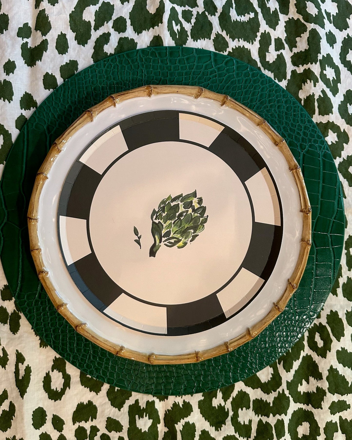 Decorative plate with green artichoke design on a leopard print fabric background