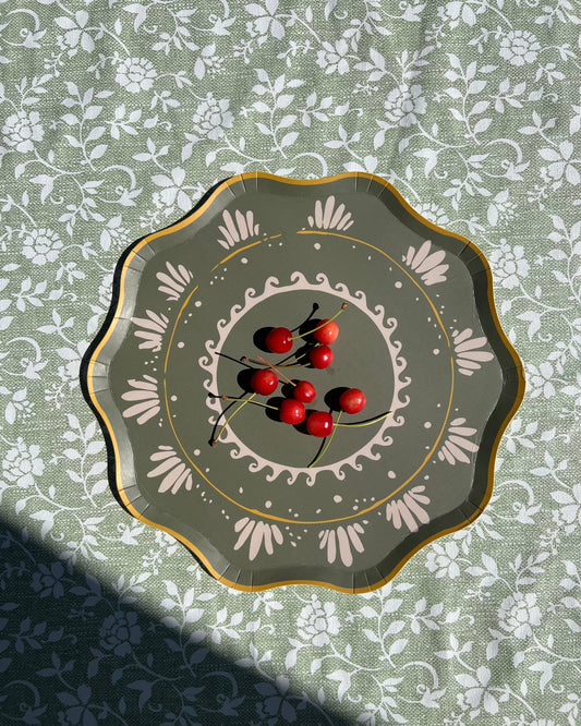 Decorative plate with red berries on a floral tablecloth