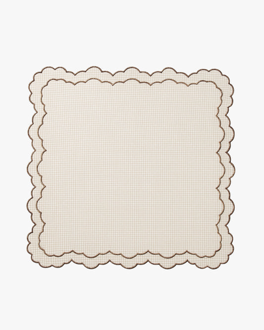Beige checkered scalloped placemat on a white background
