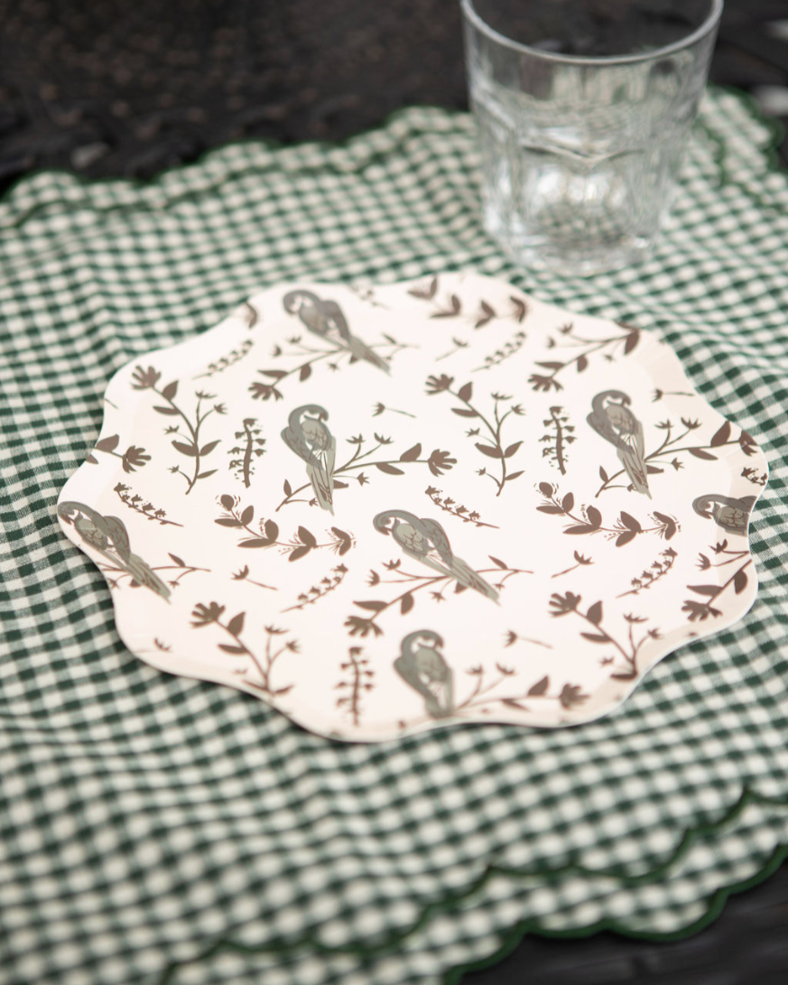 Decorative plate with bird pattern on a green checkered placemat