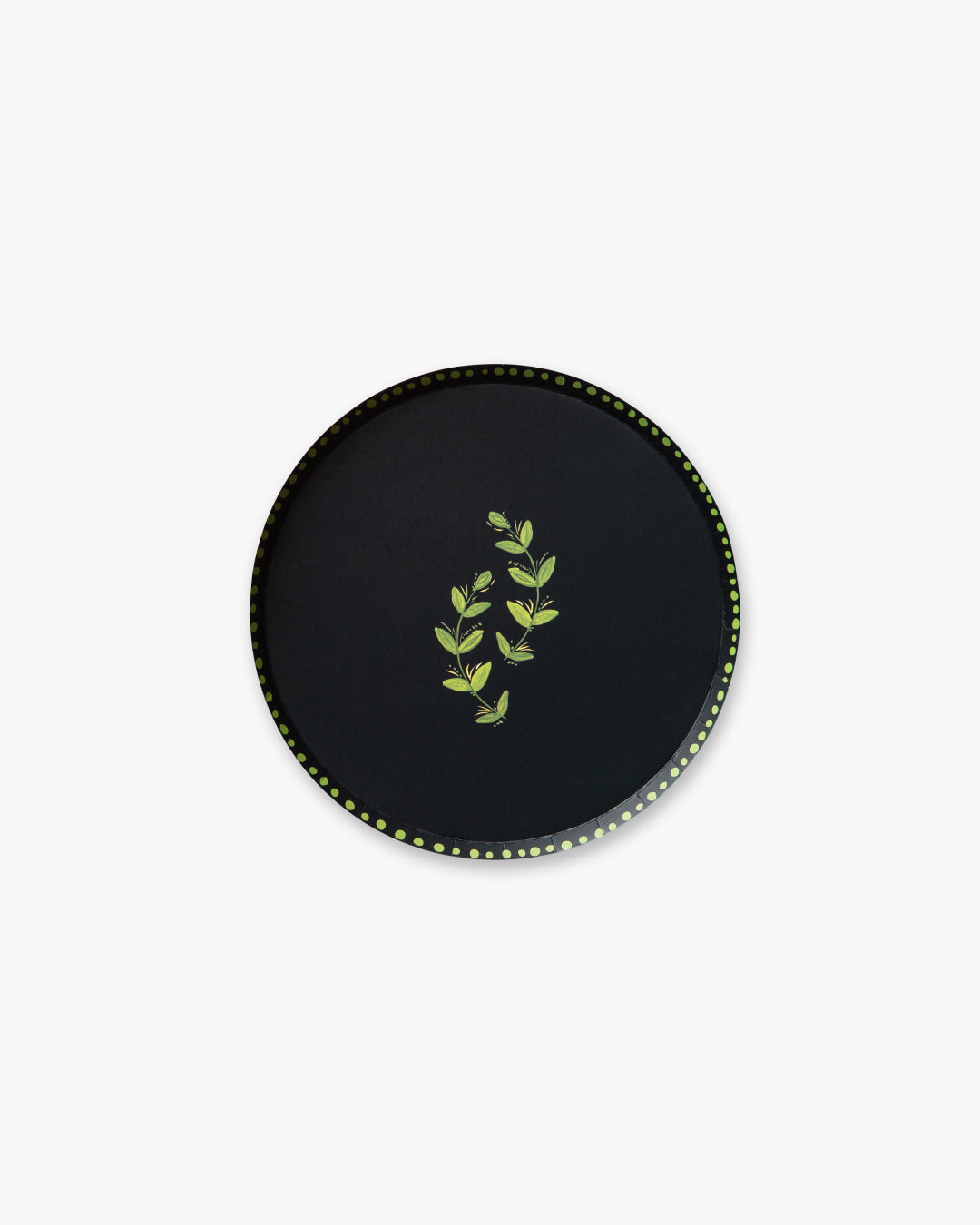 Round navy plate with green leaf design on a white background