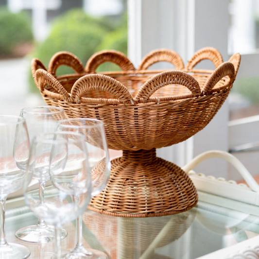 Wicker bowl on a table with glasses and a blurred outdoor background