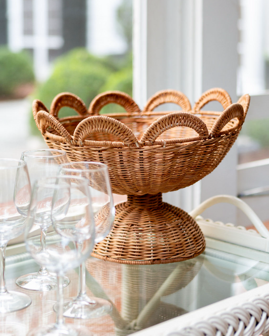 Wicker bowl on a table with glasses and a blurred outdoor background