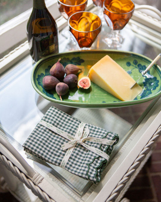 Green ceramic plate with figs, cheese, and green gingham napkins