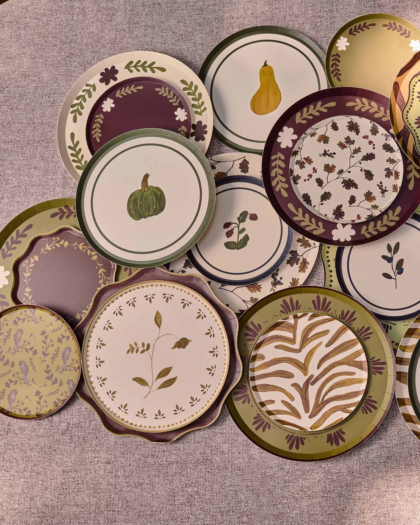 Decorative plates scattered and layered on a grey table
