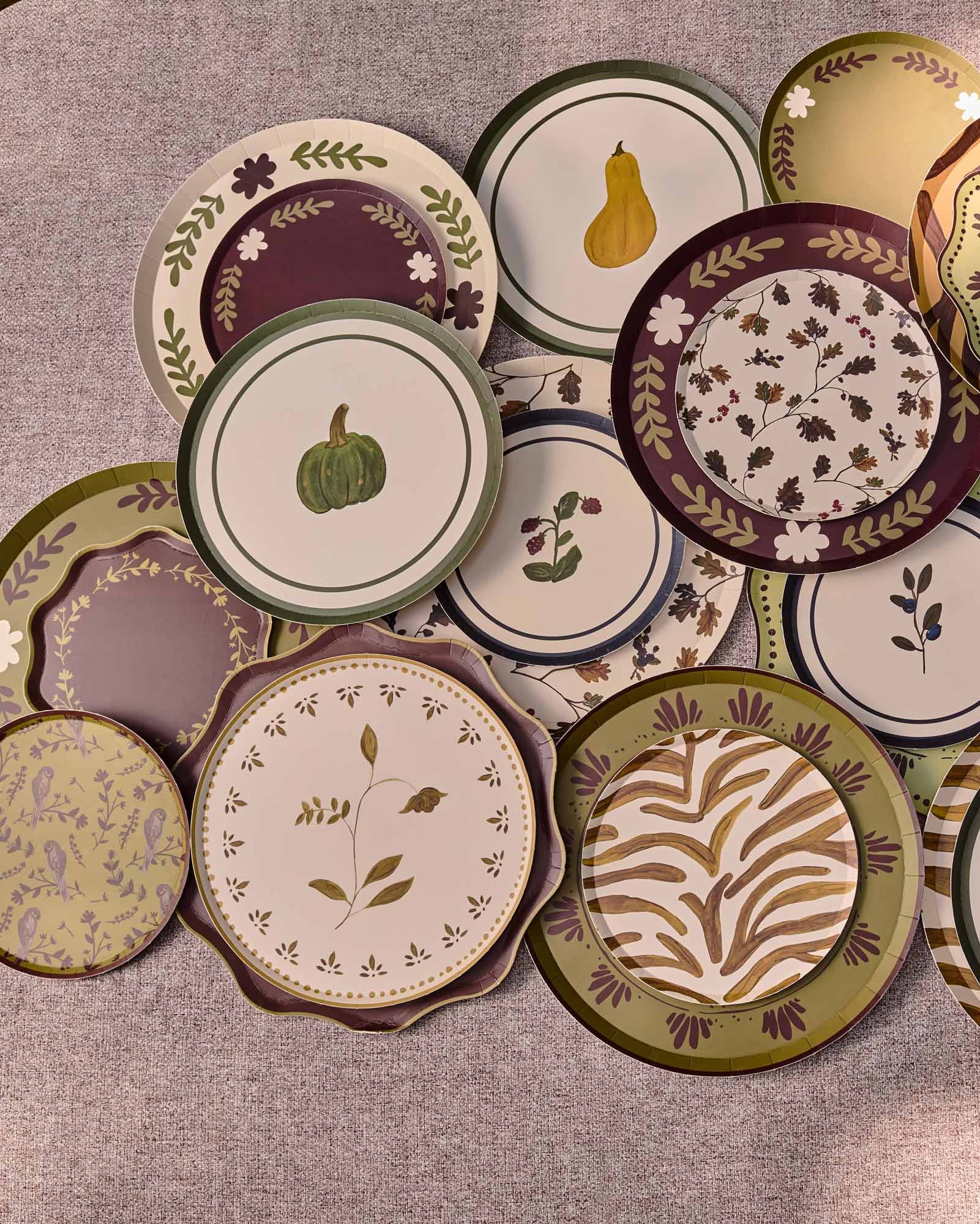 Decorative plates scattered and layered on a grey table