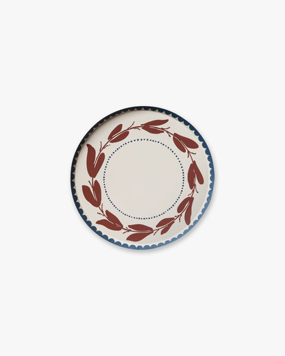 Decorative plate with a red leaf pattern on a white background