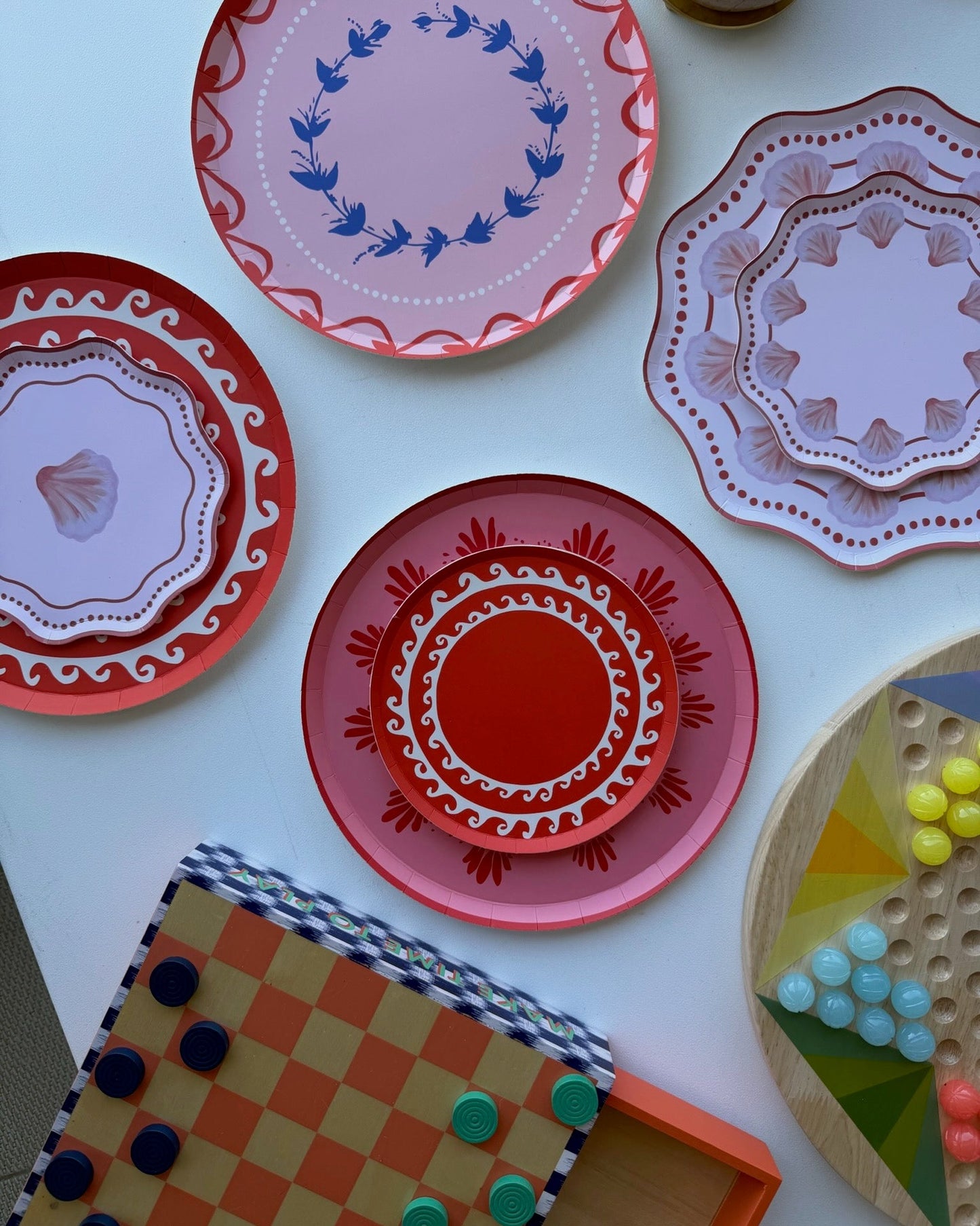 bright decorative plates on a white table with board games