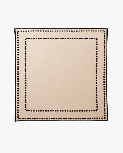 Beige placemat with black border on a white background