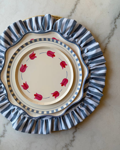 stacked plates with tulip designs on a blue and white striped placemat