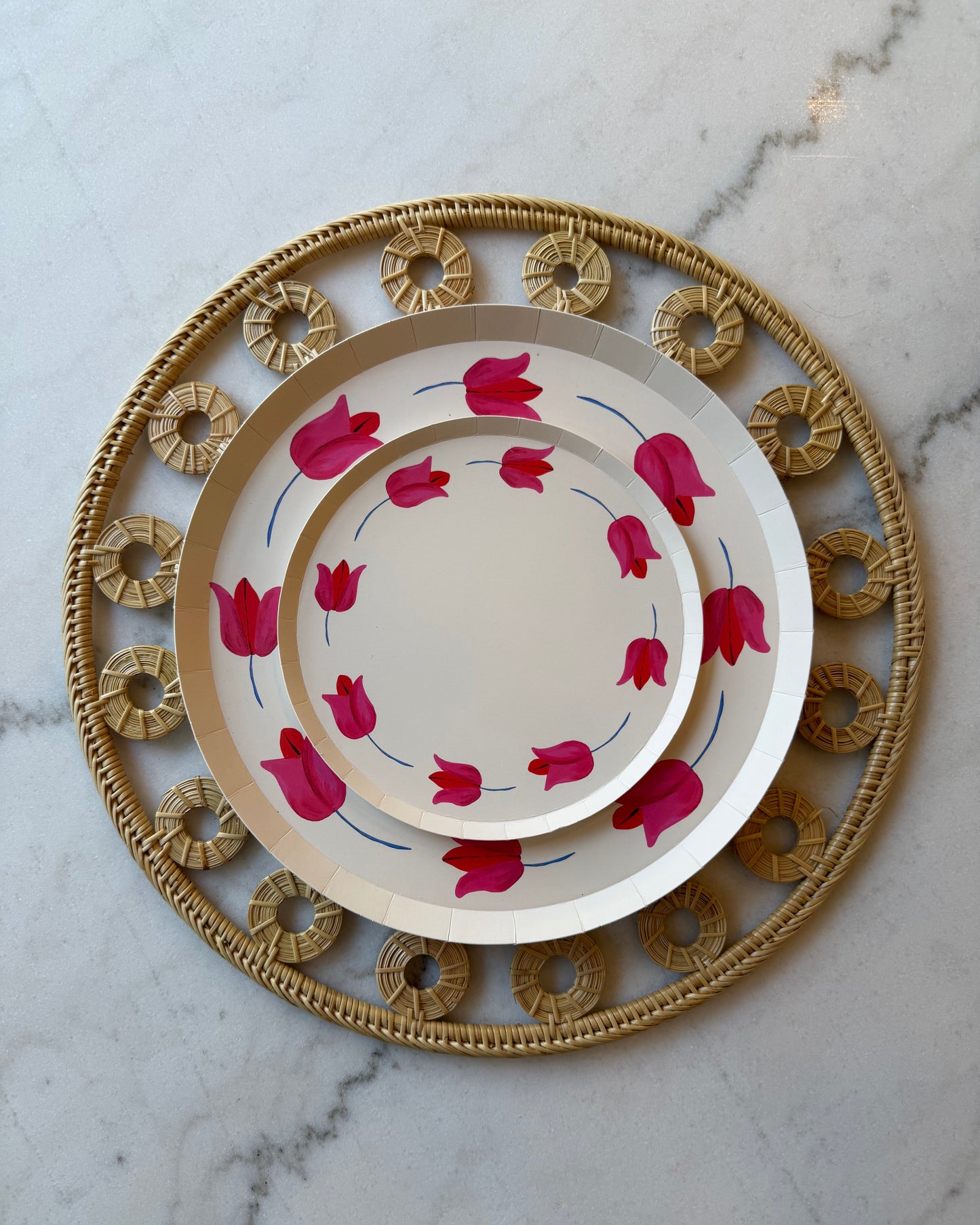 Decorative plate with pink floral design on a marble surface