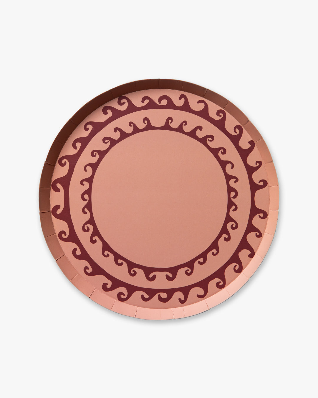 Decorative pink plate with wavy line pattern on a white background