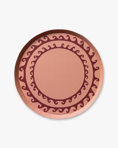 Decorative pink plate with wavy line pattern on a white background