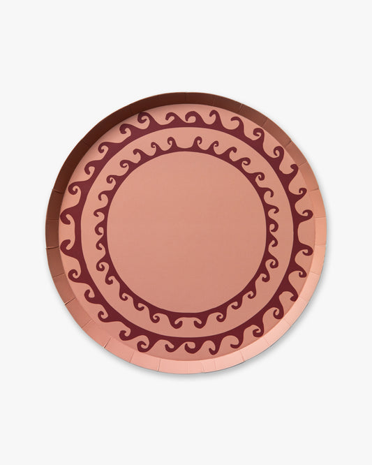 Decorative pink plate with wavy line pattern on a white background