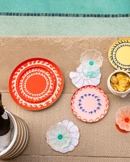 Bright colored patterned plates next to a pool