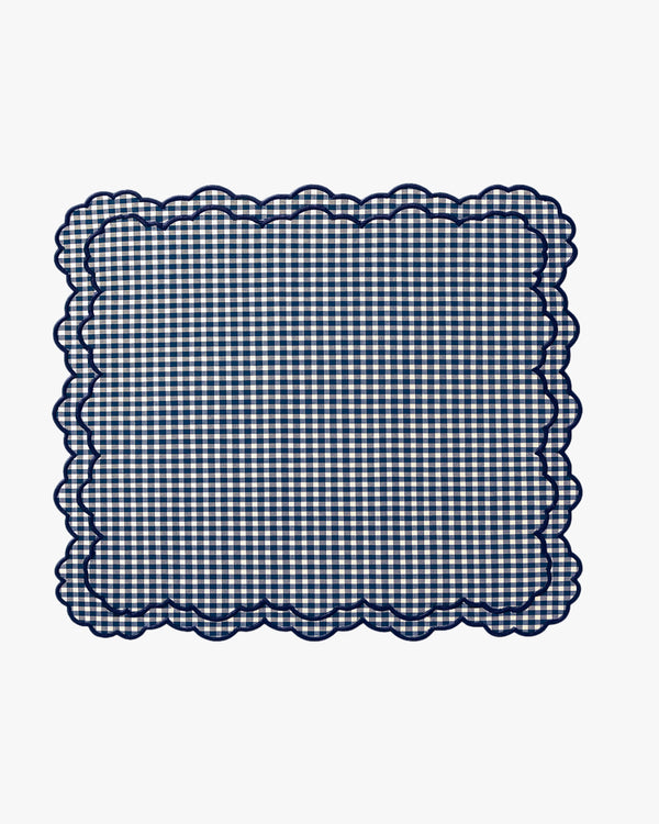 Navy blue and white checkered fabric with scalloped edge on a white background