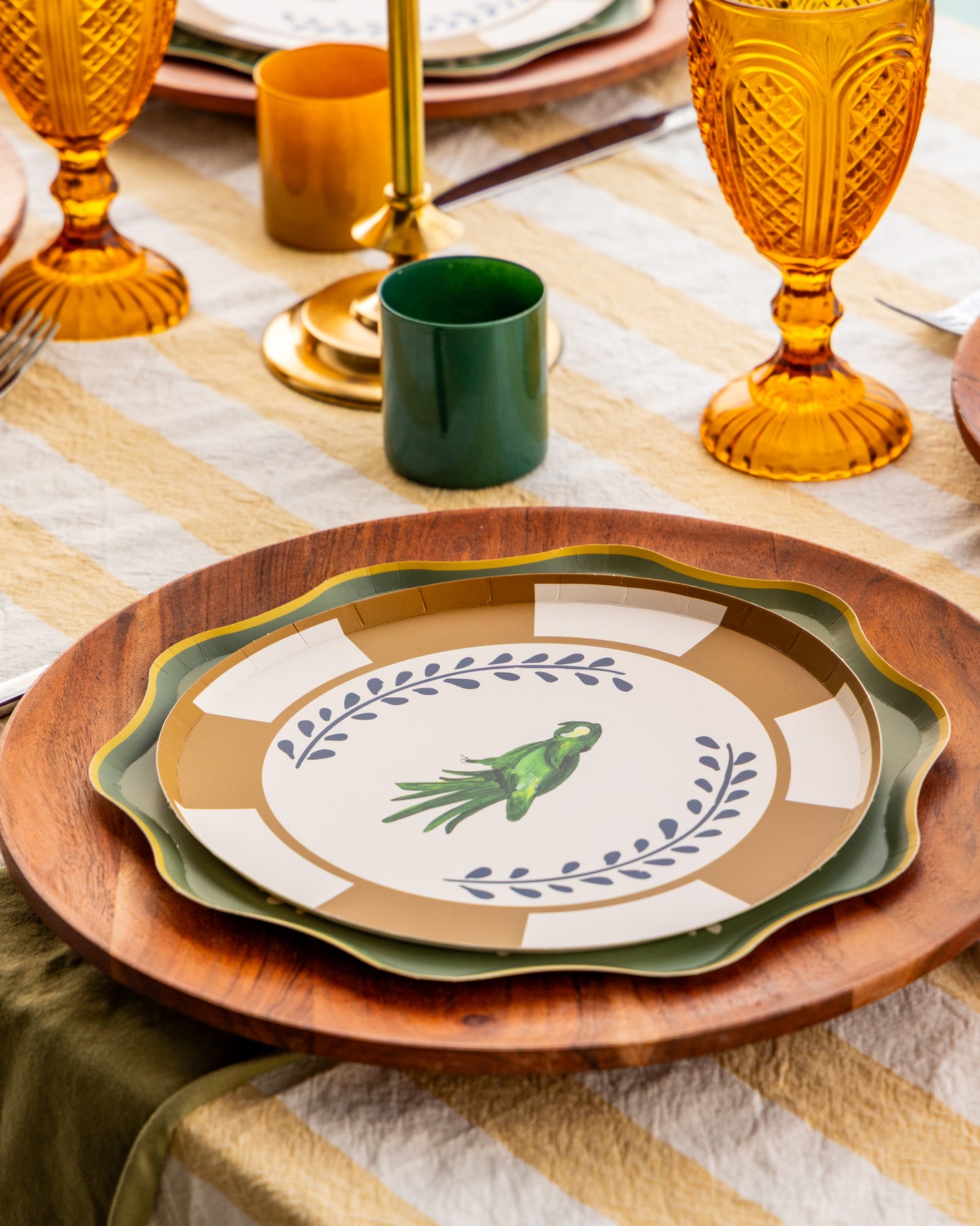a table setting with decorative plates with a parakeet in the center