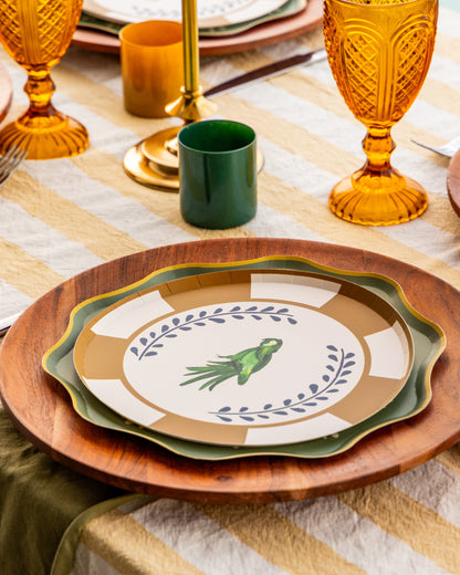 a table setting with decorative plates with a parakeet in the center