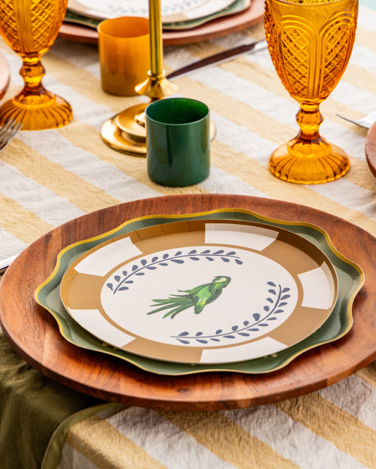 a table setting with decorative plates with a parakeet in the center