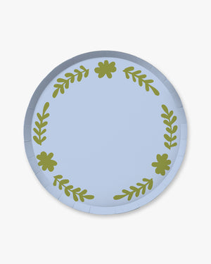 Round paper plate with green leaf pattern on a light blue background