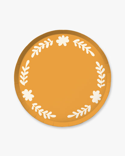 Round paper plate with floral design on an orange background
