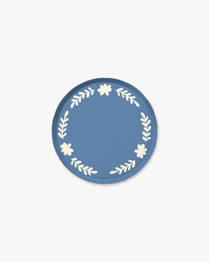 Blue paper plate with white floral designs
