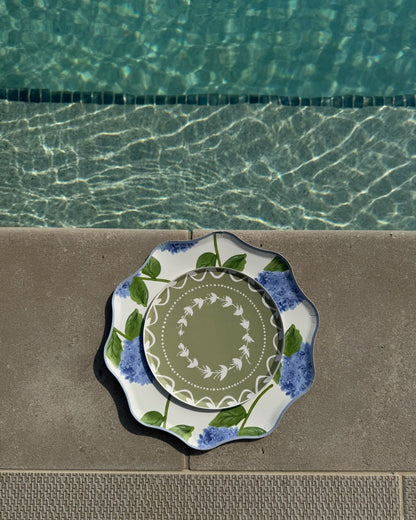 Decorative plates layered on a poolside concrete surface