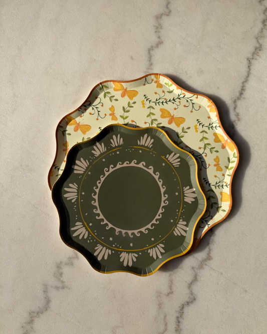 Two decorative plates on a marble surface, one with floral design and the other with geometric pattern.