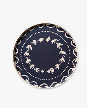 Navy blue plate with white floral pattern on a white background