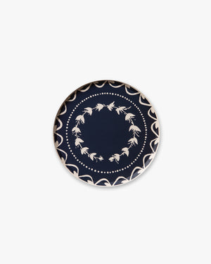 Navy blue plate with white floral pattern on a white background