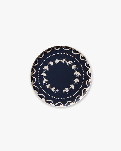 Navy blue plate with white floral pattern on a white background
