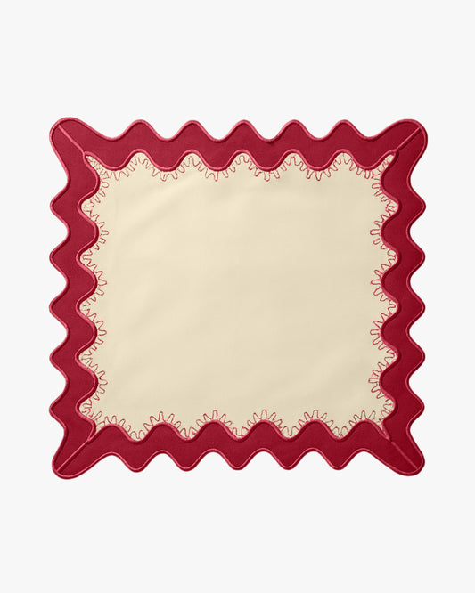 A cream napkin with a red boarder