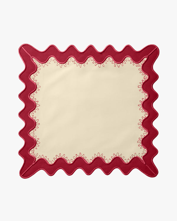 A cream napkin with a red boarder