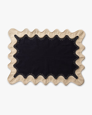 A navy placemat with white scalloped edges
